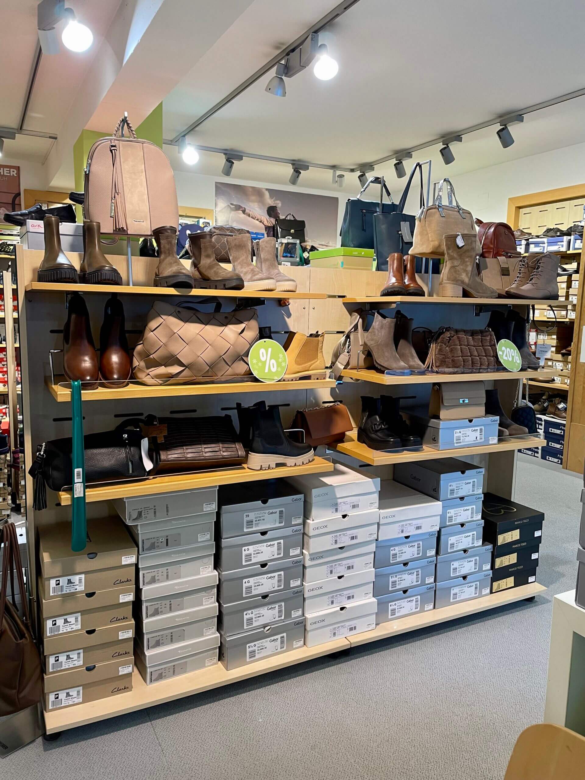 Regal mit Schuhkartons, Stiefeln, Taschen und Handtaschen in einem Geschäft