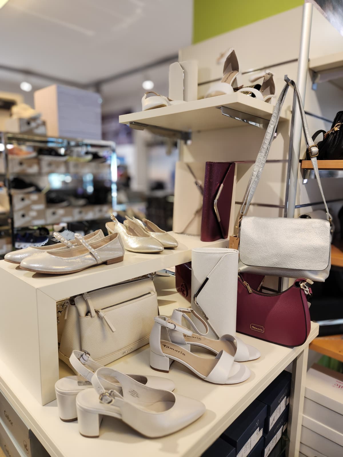 Regal mit mehreren Paaren Damenschuhen und Handtaschen in einem Geschäft