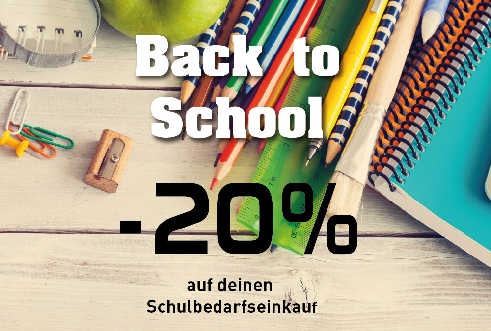 Bunte Schulutensilien mit Buntstiften, Lineal, Heften, Pinsel, Spitzer und Büroklammern auf einem hellen Holztisch.